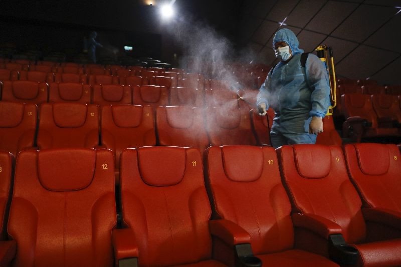 A staff member of a cinema sprays disinfectant at the cinema hall to prepare for reopening on July 1 in Kuala Lumpur, Malaysia. (Photo by Vincent Thian/AP Photo)